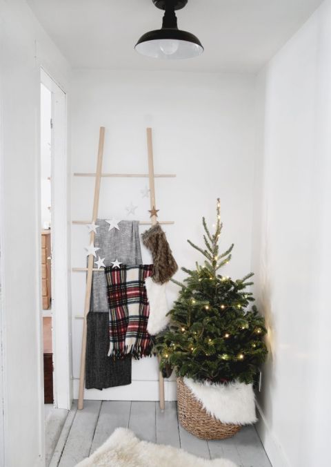 hallway with blanket ladder and small christmas tree in basket next to it